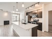 Modern kitchen features stainless appliances, a large island, and open living space at 9185 Wilde Ln # 301, Parker, CO 80134