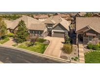 Beautiful home featuring stone accents, three-car garage, and meticulously landscaped front yard at 10687 Featherwalk Way, Highlands Ranch, CO 80126