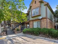 Multi-level townhome featuring brick and siding accents, landscaped front, and staircase entry to upper units at 61 S Sable Blvd # C15, Aurora, CO 80012