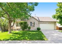 Charming single-Gathering home with a well-manicured lawn, brick facade, and attached two-car garage at 3461 Maple Cir, Brighton, CO 80601