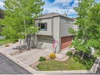 Charming two-story home with a two-car garage, inviting front yard, and mature shade trees at 766 Chimney Creek Dr, Golden, CO 80401
