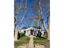 Charming single-story home with a cozy front yard framed by mature trees on a sunny day at 3910 S Grant St, Englewood, CO 80113