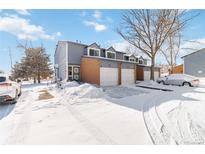 Snow covered exterior of a two-story townhome with attached garage at 1693 Carr St # A, Lakewood, CO 80214