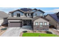 Beautiful two-story home featuring a well-maintained yard, a two-car garage, and a charming stone facade at 18541 W 93Rd Pl, Arvada, CO 80007