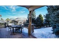 Outdoor deck with table and chairs showcasing beautiful mountain views and snow-covered scenery at 76 Buckthorn Dr, Littleton, CO 80127