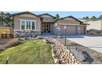 Charming stucco home with stone accents, manicured front yard, and inviting curb appeal at 1766 Summerglow Ln, Monument, CO 80132