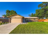 Charming single-story home with well-maintained lawn, attached two-car garage, and beautiful brick accents at 3643 E Lake Dr, Centennial, CO 80121