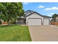 Beautiful two-story home featuring a three-car garage and lush front lawn at 17303 E Dewberry Cir, Parker, CO 80134