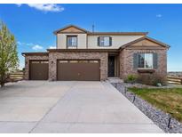 Charming two-story home featuring a three-car garage, brick facade, landscaped yard and inviting front door at 7207 S Scottsburg Way, Aurora, CO 80016