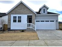 Beautiful home with gray siding, stone accents, white trim, and an attached two car garage at 17196 W 92Nd Loop, Arvada, CO 80007