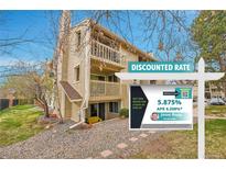Tan two-story home featuring dual balconies, a chimney, and a well-kept, minimalist gravel yard at 4066 S Atchison Way # 102, Aurora, CO 80014