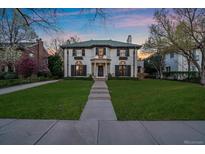 Stately two-story home with a green tile roof and a manicured front lawn at 140 Race St, Denver, CO 80206