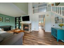 Inviting living room with a cozy fireplace, built in shelving, and views to the second story at 4720 S Dudley St # 44, Littleton, CO 80123