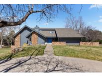 Contemporary home with stone accents, blue front door and lush front lawn at 9505 Poundstone Pl, Greenwood Village, CO 80111