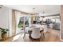 Bright kitchen with a breakfast nook, black backsplash, stainless steel appliances, and hardwood floors at 4150 S Rome St, Aurora, CO 80018