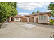 Spacious home featuring an expansive driveway and attached three-car garage at 2069 Garrison St, Lakewood, CO 80215