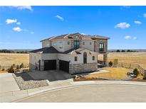 Stunning two-story stucco home with a three-car garage and beautifully landscaped front yard on a bright, sunny day at 15322 Irving Ct, Broomfield, CO 80023