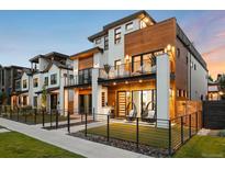 Modern exterior with white brick, wood accents, balconies, fenced yard, and hanging chairs at 340 Milwaukee St, Denver, CO 80206