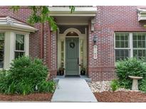Close-up of the charming brick home showcasing the front door and well-maintained landscaping at 9165 Kornbrust Dr, Lone Tree, CO 80124