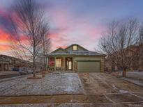 Charming single Gathering home featuring a covered porch with stone accents and a two car garage at 23236 Chapel Hill Pl, Parker, CO 80138