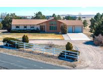 Ranch style home with attached garage, decorative white fence and a rural setting at 40154 E Colorado Ave, Bennett, CO 80102