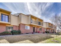 Townhome exterior with brick facade, balconies, manicured lawn, and community landscaping at 750 Tabor St # 46, Lakewood, CO 80401