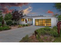 Charming single-story home with a modern garage door and well-maintained front yard at dusk at 2675 S Eudora St, Denver, CO 80222