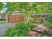Charming home featuring a two-car garage, lush landscaping, and a brick walkway leading to the front door at 3966 Bosque Ct, Boulder, CO 80301