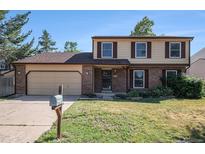 Charming two-story home with a brick facade, attached two-car garage, and well-maintained front yard at 15892 E Arkansas Pl, Aurora, CO 80017