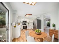 Bright kitchen features white cabinets, stainless steel appliances, and a light wood floor at 15892 E Arkansas Pl, Aurora, CO 80017