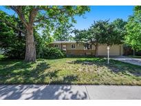 Charming home with lush landscaping, mature trees, and well-maintained lawn at 6780 Allison St, Arvada, CO 80004