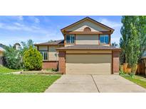 Charming two-story home featuring a two-car garage, manicured lawn, and classic architectural details at 19937 E Loyola Pl, Aurora, CO 80013