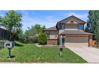 Two-story home with a two-car garage, brick and siding exterior, and front lawn at 19937 E Loyola Pl, Aurora, CO 80013