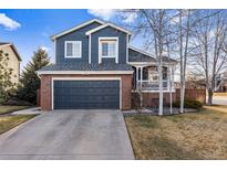 Charming two-story home with a brick facade, blue siding, and well-maintained front yard at 11899 Elizabeth Cir, Thornton, CO 80233