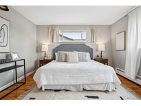 Inviting main bedroom featuring a gray headboard, patterned bedding, and hardwood floors at 2930 S Birch St, Denver, CO 80222