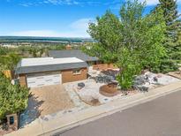 Charming brick ranch with mature landscaping, an attached garage, and spectacular mountain views at 14091 W Exposition Dr, Lakewood, CO 80228