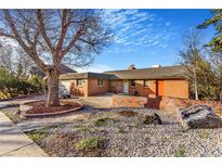 Charming brick home featuring a beautifully landscaped front yard and walkway at 14091 W Exposition Dr, Lakewood, CO 80228