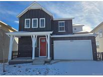 Charming two-story home boasts a modern design, complemented by a bright red door and a spacious two car garage at 8820 Whiteclover St, Littleton, CO 80125