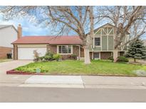 Charming front yard with mature trees and a well-maintained lawn enhance this home's curb appeal at 14867 E Harvard Ave, Aurora, CO 80014