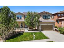Charming two-story home featuring a well-manicured lawn, attached garage, and inviting front porch at 2263 S Loveland St, Lakewood, CO 80228