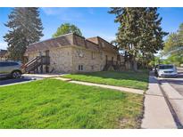 Two-story apartment building featuring well-maintained lawn and exterior stairs for upper units at 1390 Everett Ct # 105, Lakewood, CO 80215
