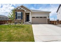 Charming home with stone accents, a well-manicured lawn, and a two-car garage at 944 Alpine Ridge St, Erie, CO 80516