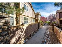 Charming townhome exterior featuring stone accents, wood siding, and a well-maintained walkway with landscaping at 5660 S Algonquian Way # C, Aurora, CO 80016