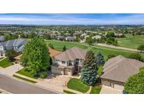 Stunning aerial view of home on golf course with lush landscaping and mature trees at 6323 S Sicily Way, Aurora, CO 80016