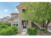 Charming townhome exterior with stone facade, landscaped yard, and welcoming entrance at 2502 S Bahama Cir # B, Aurora, CO 80013