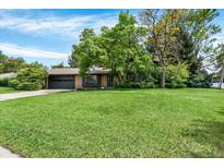Well-maintained front yard with lush green grass and mature trees provides curb appeal at 400 S Hoyt St, Lakewood, CO 80226