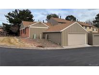 This is a view of the home's exterior including the brick siding, garage, and well-maintained landscaping at 7101 W Yale Ave # 1206, Denver, CO 80227