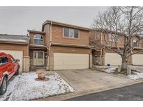 Two story home with tan wood facade, two car garage, and decorative arched window at 45 Wright Ct, Lakewood, CO 80228