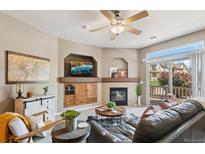 Cozy living room featuring a fireplace, TV, comfortable seating, and access to the outside at 10818 Cimarron St # 1102, Firestone, CO 80504