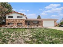 Charming brick home with an attached garage and manicured front lawn at 1010 Kennedy Dr, Westminster, CO 80234